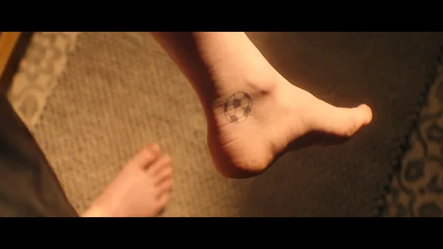 Emma Myers showing a bare foot with temporary markings in a scene.
