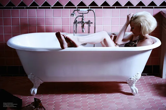 Kirsten Dunst reclining in a freestanding bathtub.