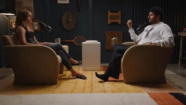 Emma Watson: seated in heels during a studio conversation.