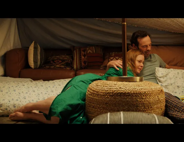 Amy Adams sitting with a companion during a screen scene.
