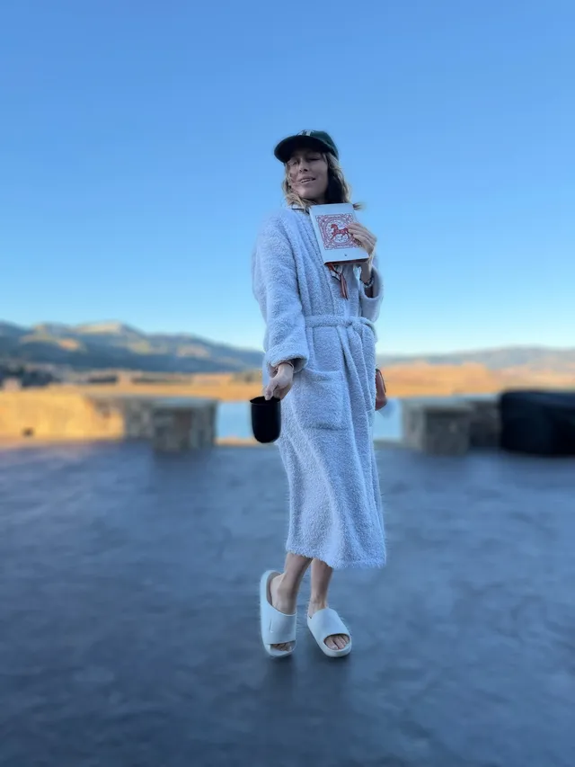 Jessica Biel standing outdoors in a pale dress and platform heels.