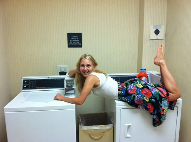 AnnaSophia Robb leaning on a washing machine in a playful portrait.