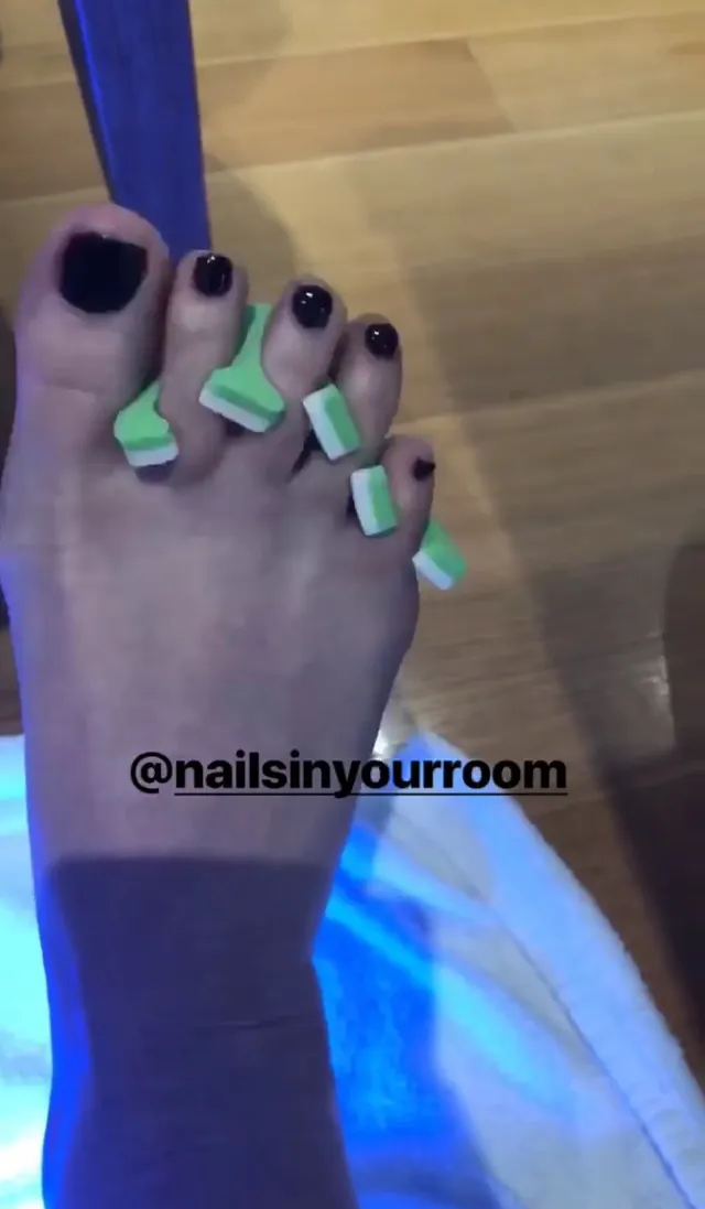 Jennifer Love Hewitt showing painted toenails with foam toe separators.