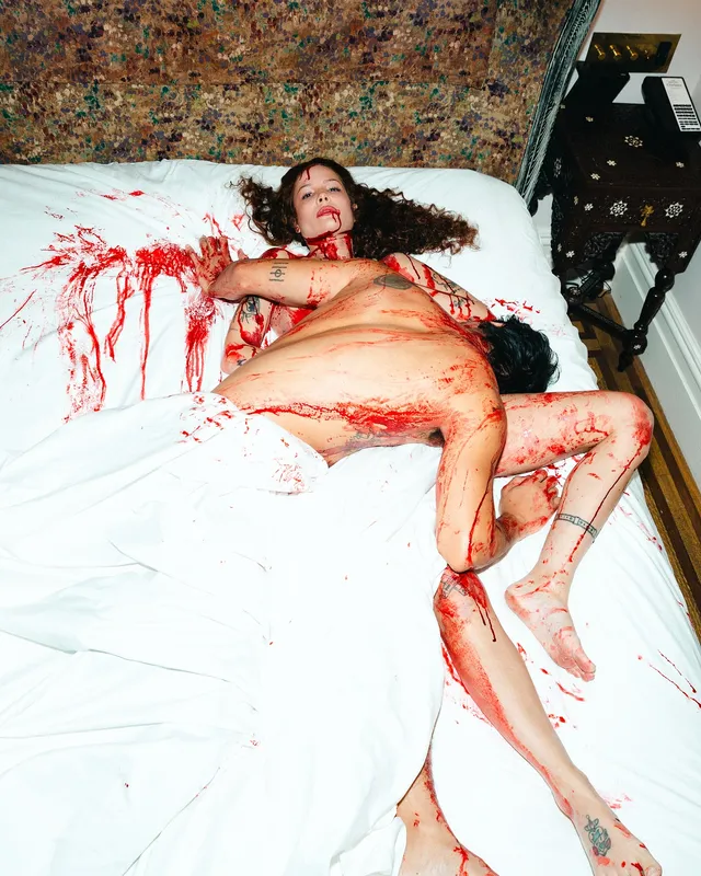 Halsey a theatrical horror portrait on a white bed.