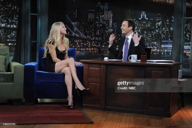 Anna Kournikova wearing black heels and a dark dress during a television interview.