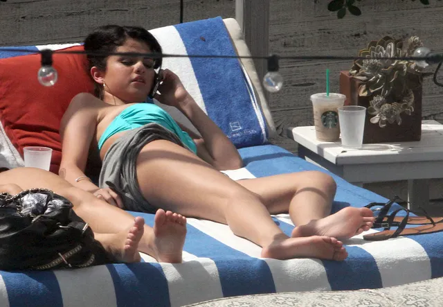 Selena Gomez reclining on a sun lounger.