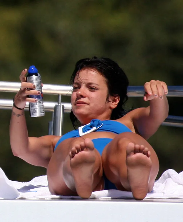 Lily Allen: relaxing outdoors with both bare soles raised.