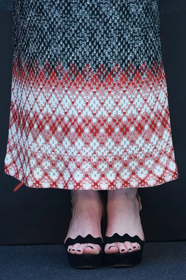 Bryce Dallas Howard a close-up of black open-toe heels beneath a patterned dress.