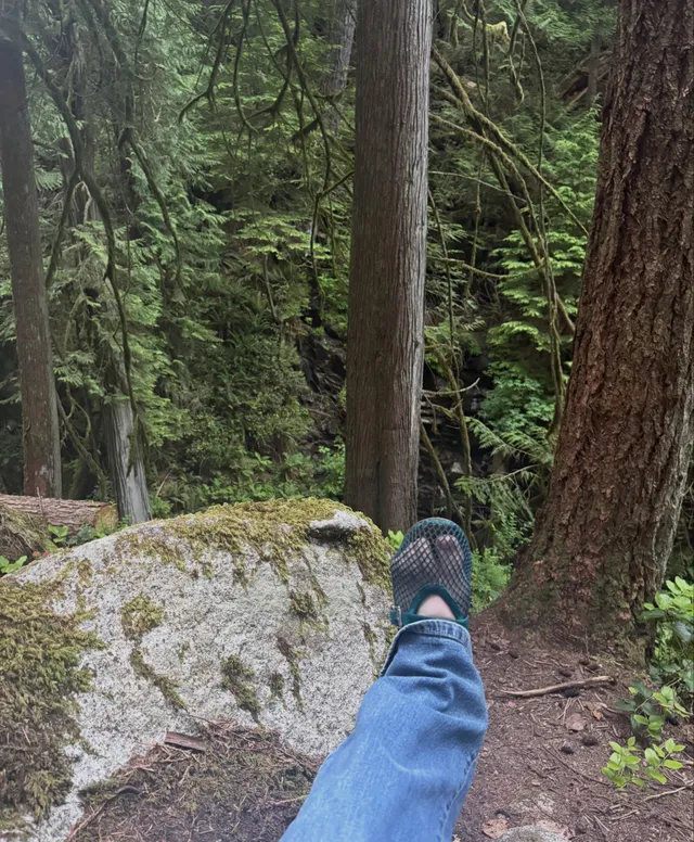 Sophie Thatcher showing a white sock and mesh shoe on a woodland walk.