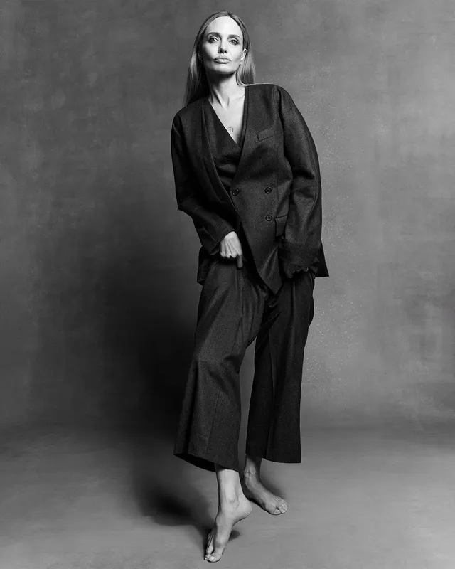 Angelina Jolie a monochrome studio portrait in a dark robe.