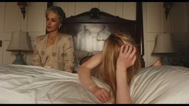 Sarah Pidgeon appearing in a bedroom scene in a black dress.