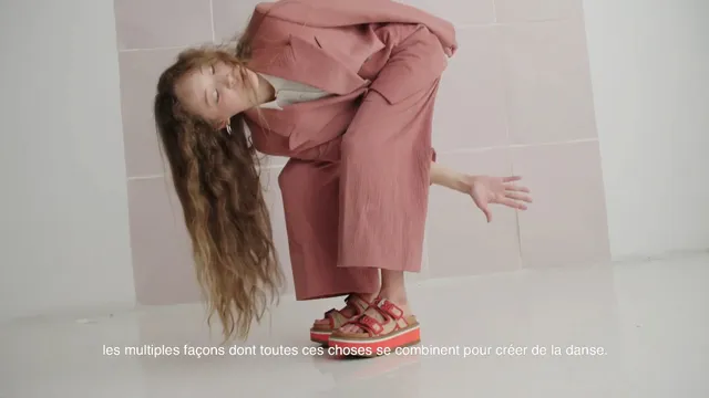 Havana Rose Liu crouching in a pink suit and red sandals.
