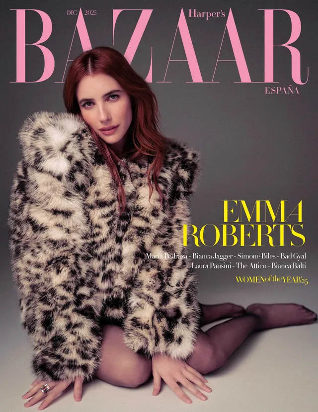 Emma Roberts posing in patterned stockings and a coat for a magazine cover.