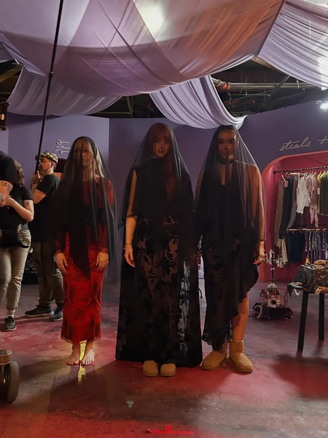 Victoria Pedretti standing with companions during a screen scene.