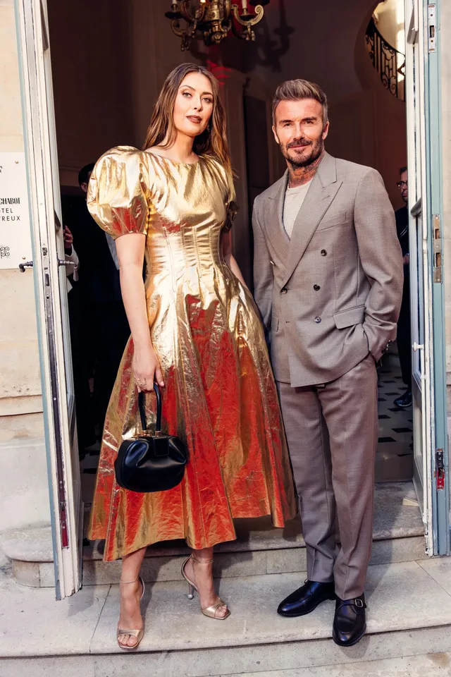 Maria Sharapova wearing heeled sandals and a patterned dress beside a companion at an evening event.