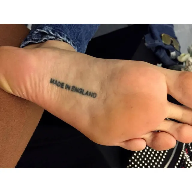 Cara Delevingne showing the tattoo on the sole of her foot.