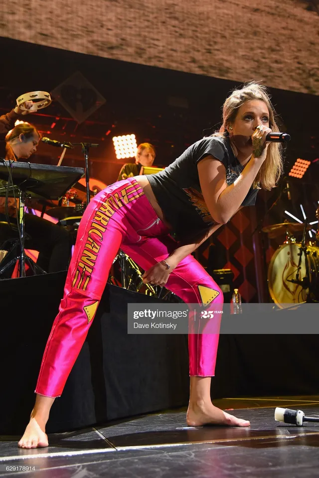 Tove Lo singing barefoot on stage in pink trousers.