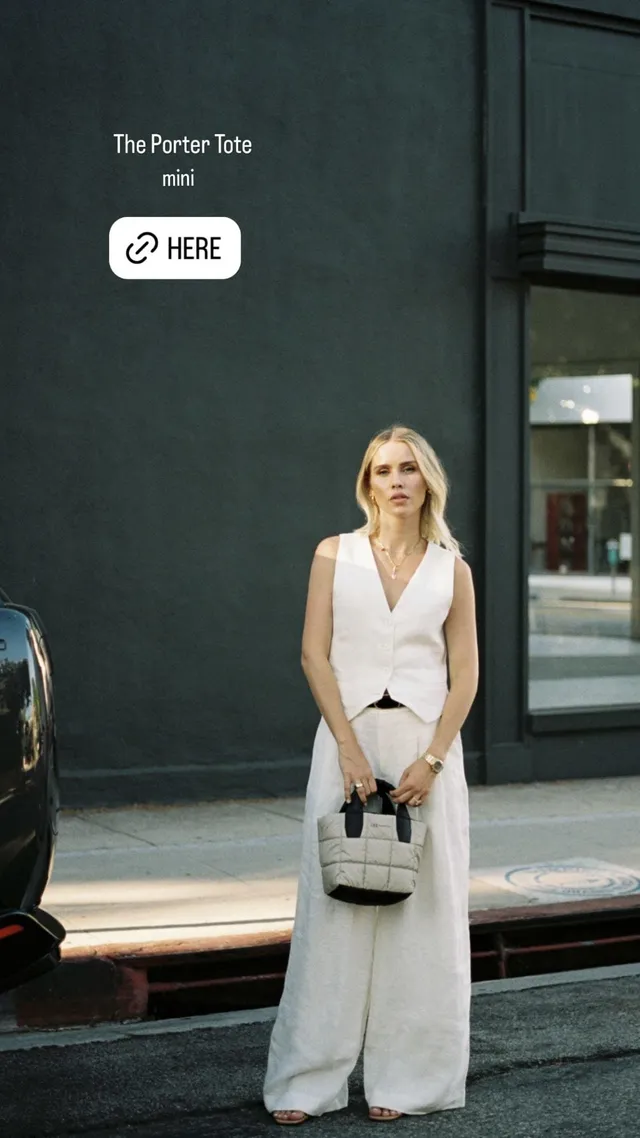 Claire Holt posing outdoors in a white outfit.