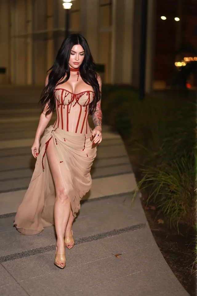 Megan Fox walking outside in a pale pink dress.