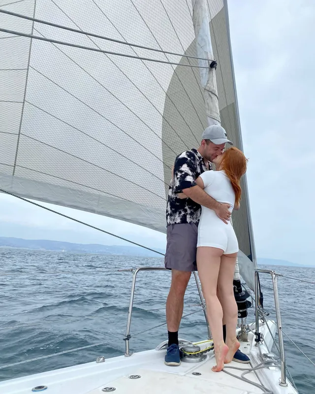 Ariel Winter embracing a companion on the deck of a sailboat.