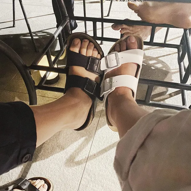 Maia Mitchell wearing flat sandals beside a companion.