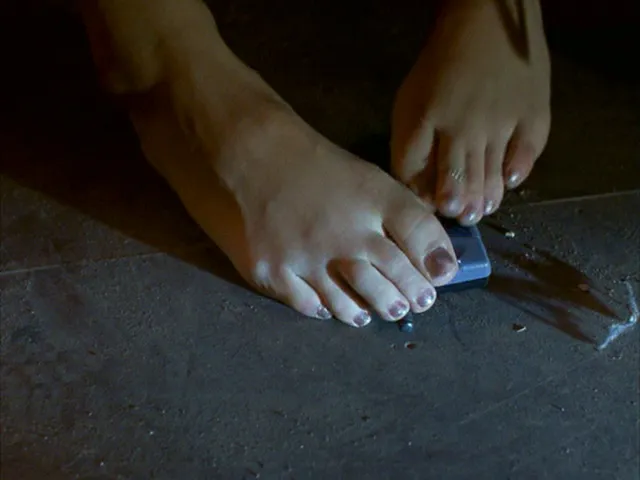 Jessica Alba resting bare feet on a wooden floor.