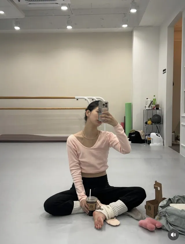 Bae Suzy sitting barefoot in a dance studio.