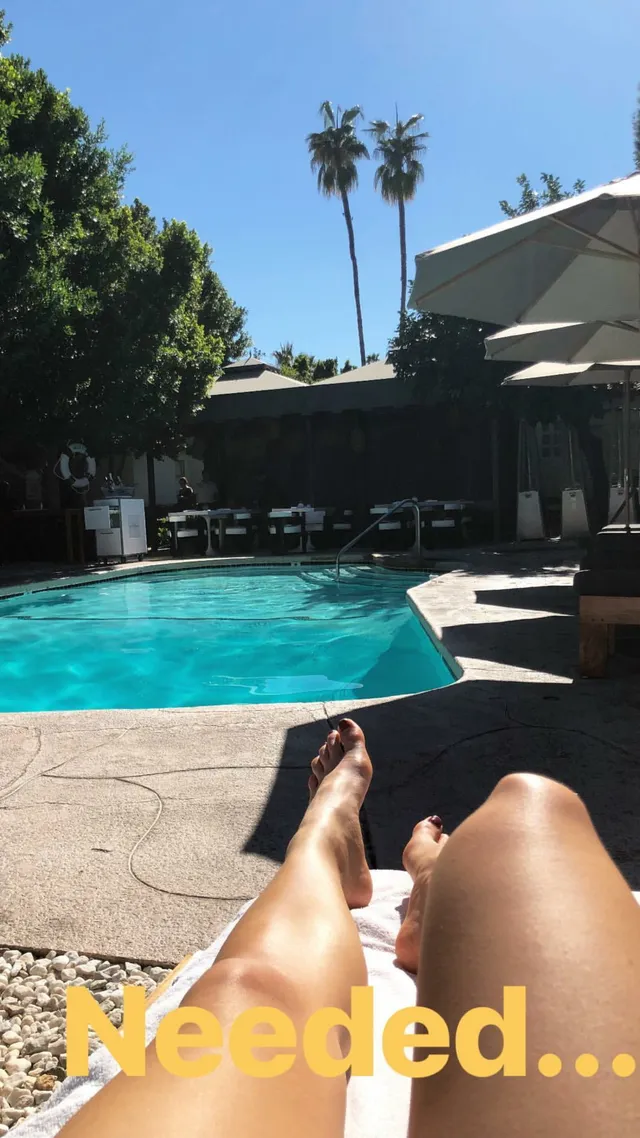 Danielle Campbell relaxing on a lounger beside a swimming pool.