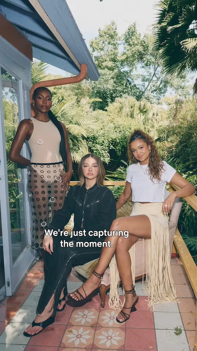 Madelyn Cline sitting with two women on an outdoor patio.