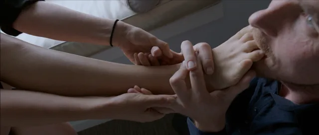 Natalie Portman appearing in a scene with a bare foot held beside her.