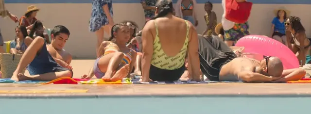 Sierra Capri sitting with friends by a swimming pool in a scene.