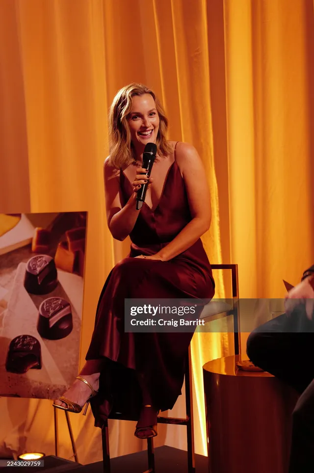 Leighton Meester sitting onstage holding a microphone.