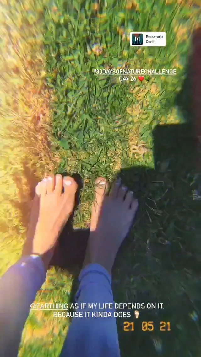 María Gabriela de Faría standing barefoot outdoors on grass.