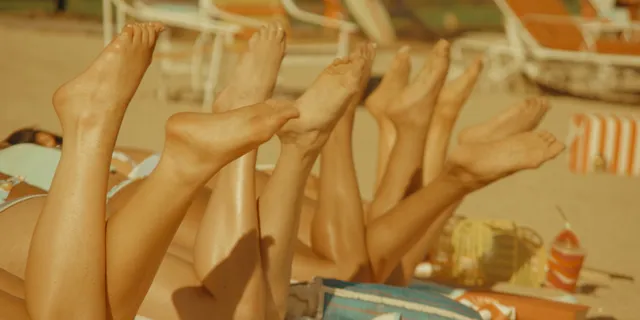 Sabrina Carpenter raising her feet while lying down.