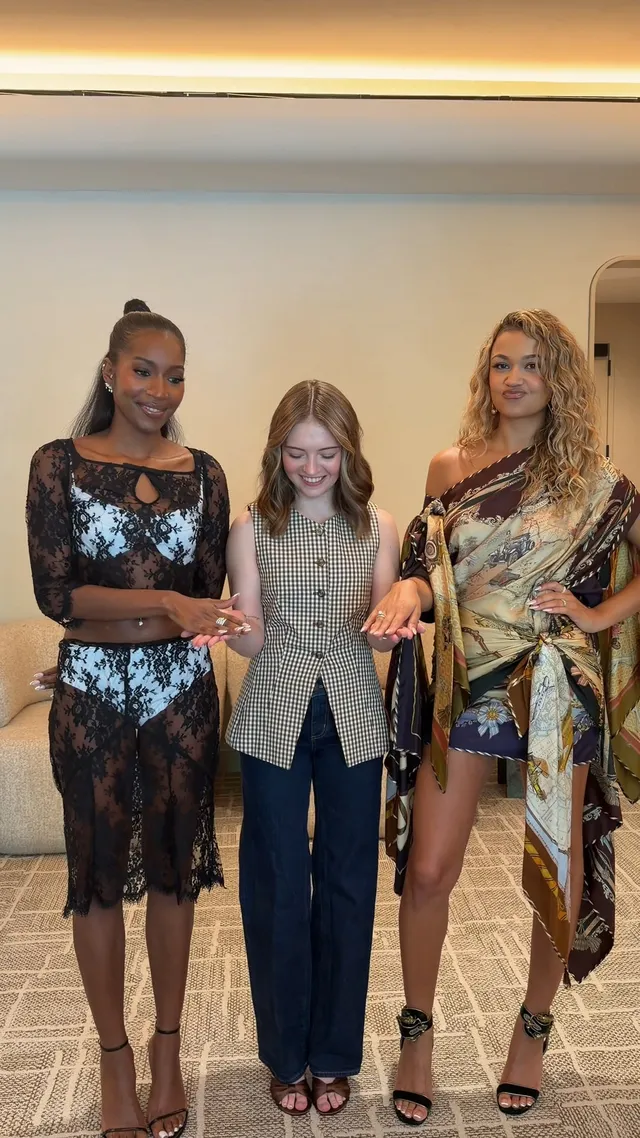 Madison Bailey posing with guests in a patterned dress and black heels.