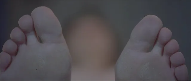 Léa Seydoux resting with her feet toward the camera in a screen scene.