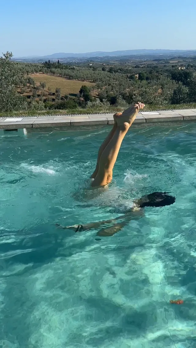 Jennifer Garner swimming in a pool overlooking hills.