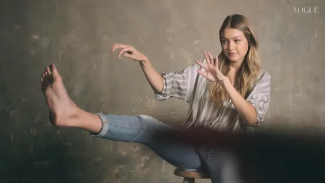 Gigi Hadid sitting with one bare foot extended during a studio interview.