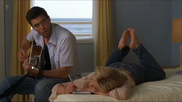 Britney Spears a reclining screen scene beside a guitarist.