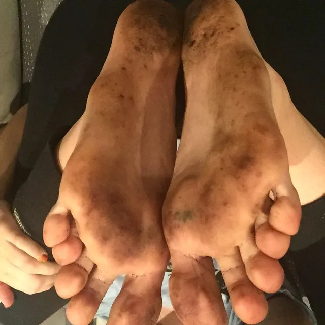Miley Cyrus showing bare soles with sand marks in a close up.