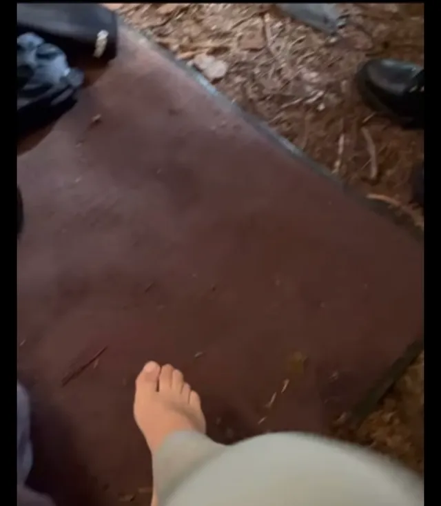 Melissa Barrera showing a bare foot beside an outdoor seat.