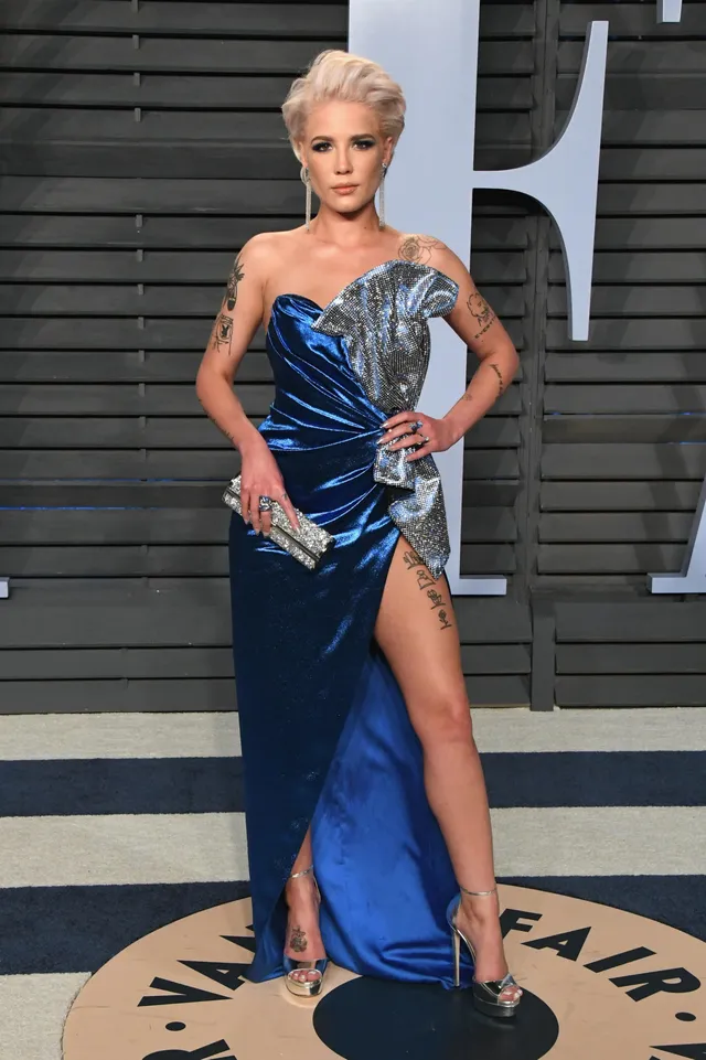 Halsey posing in a blue gown and heels at an event.