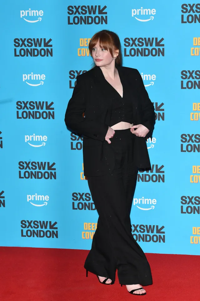 Bryce Dallas Howard posing at a premiere in a black outfit.
