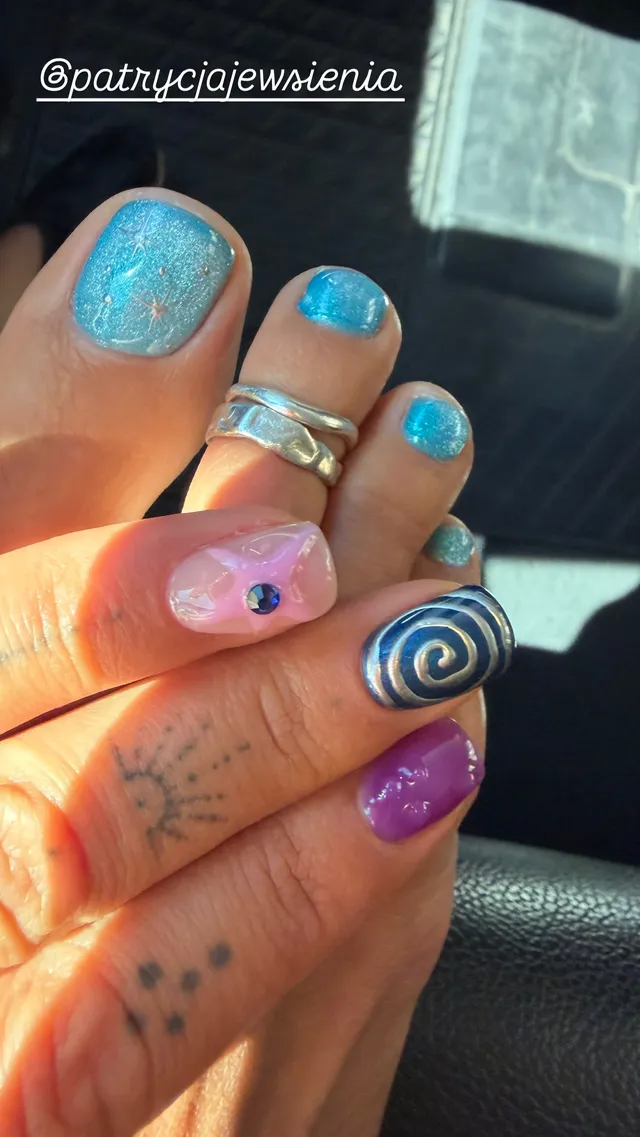 Rita Ora showing a turquoise pedicure beside a colourful manicure.