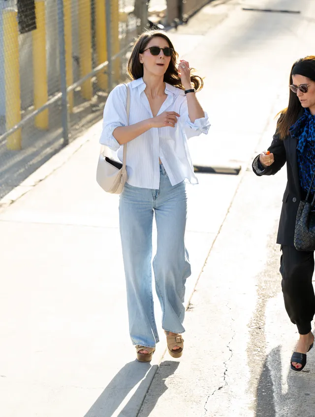 Melissa Benoist walking outdoors beside another woman in wedge heels.