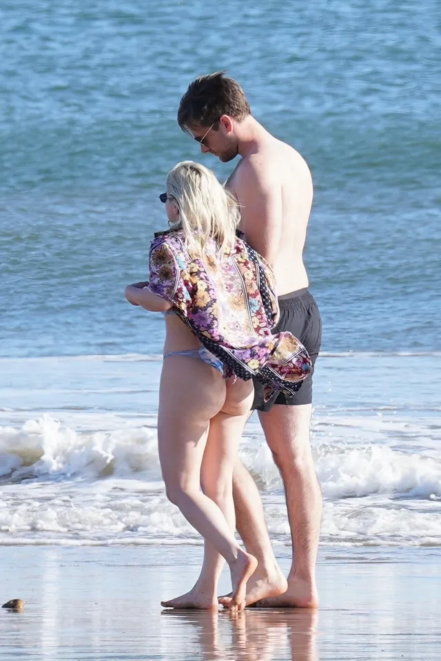Ariel Winter standing with a companion at the shoreline.