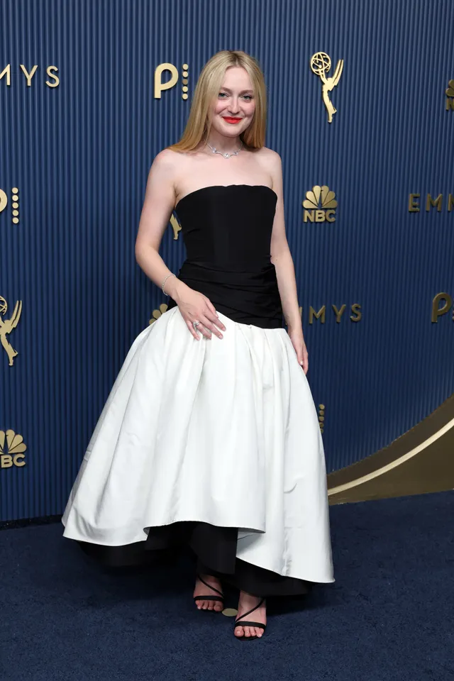 Dakota Fanning wearing a black and white dress with sandals at an awards event.