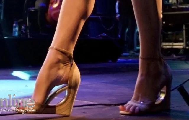 Lana Del Rey wearing metallic heels on stage.