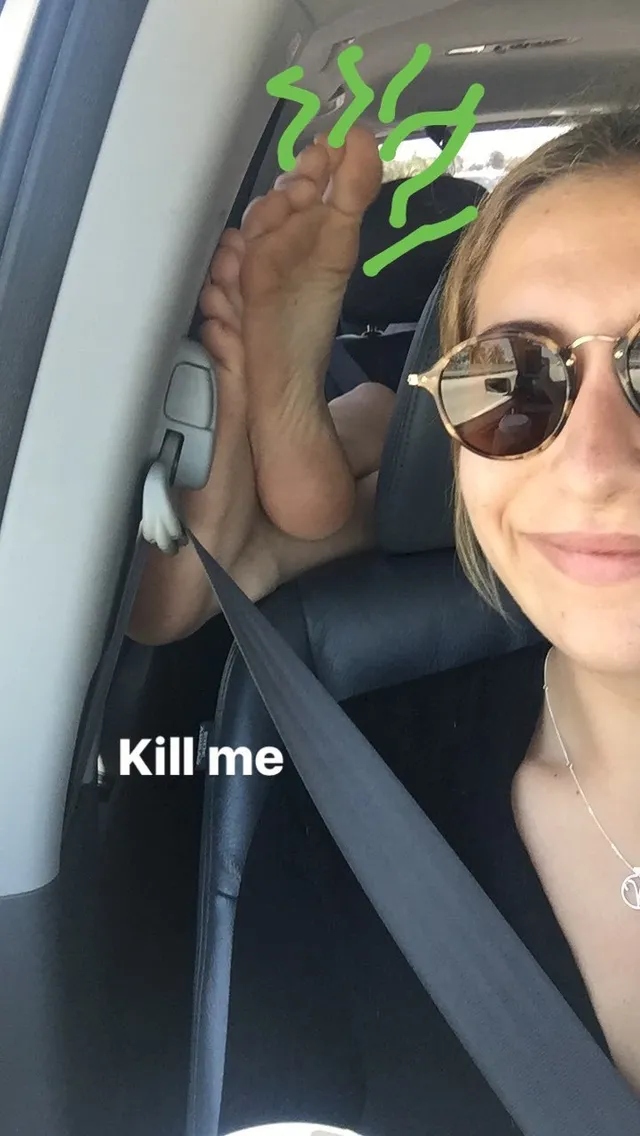 Dakota Johnson showing bare soles in a vehicle selfie.