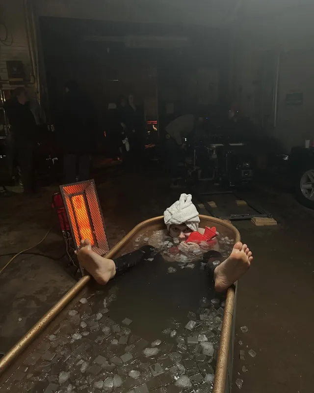 Dafne Keen resting bare feet at the edge of a bath.